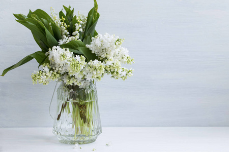春的白丁香和山谷百合花束，w 上的花瓶里