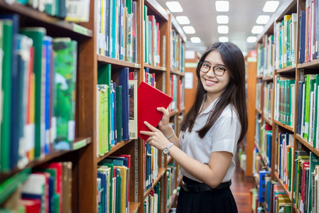 放在订购图书的开朗女亚洲学生返回房颤