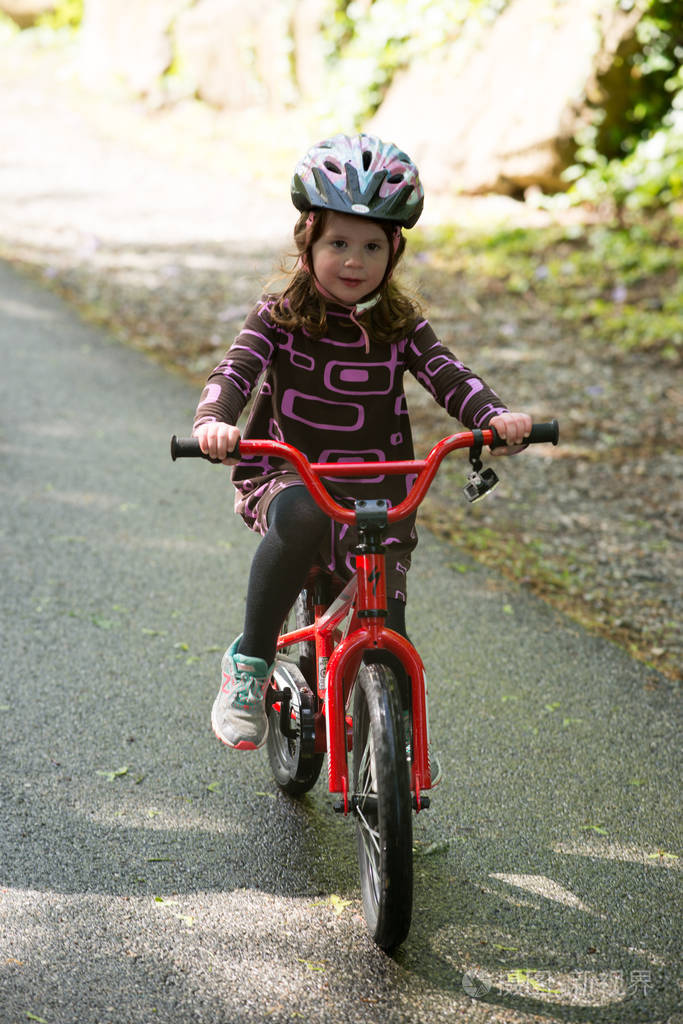 年轻女孩骑自行车铺的小路上