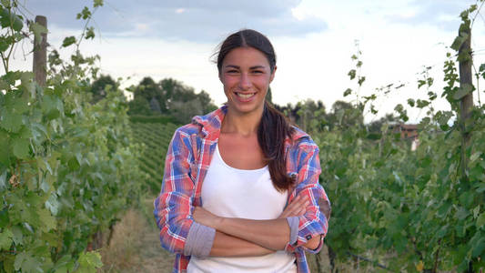 美丽的女孩 女 农民微笑着看着葡萄的领域，在白色的背心，一件衬衫 绿色背景概念生态 酒 生物产品 检查 水 天然