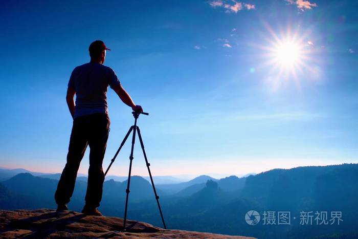 照片 专业摄影师陪三脚架上悬崖和思维.