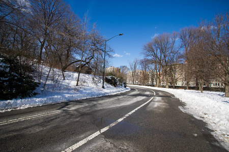 纽约中央公园的弯道和雪的道路与蓝天