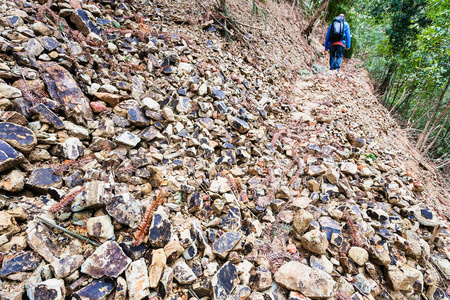 游客在山体滑坡的道路上行走图片