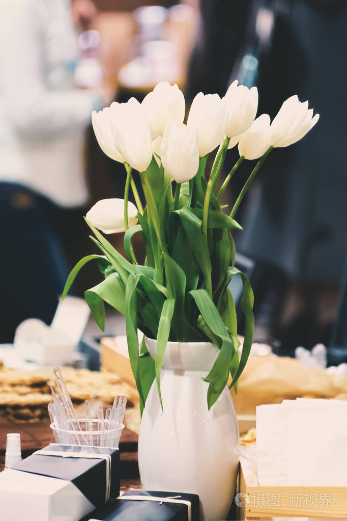 桌子上花瓶里的白色郁金香花束