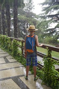 在夏天的雨下的背包成本的青少年