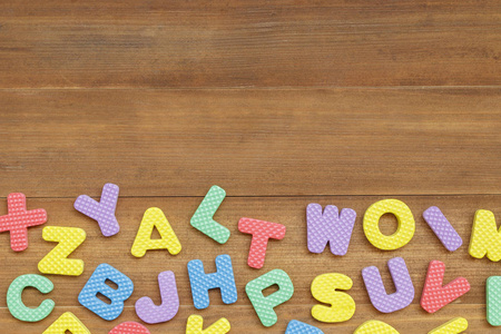 泡沫木制背景上的英文字母字母图片