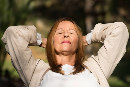 快乐轻松的女人闭上眼睛户外