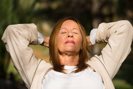 快乐轻松的女人闭上眼睛户外