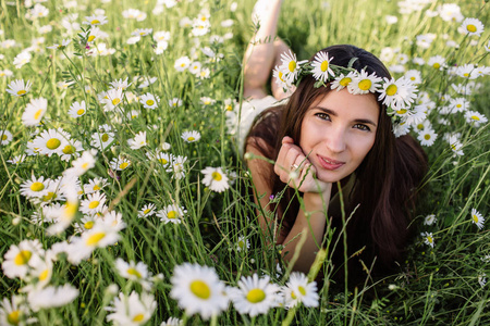 美丽的女人享受黛西场 漂亮的女性，躺在草地上的花朵，漂亮的姑娘，放松户外，有乐趣，抱着植物 快乐的年轻女人和春绿色自然，和谐