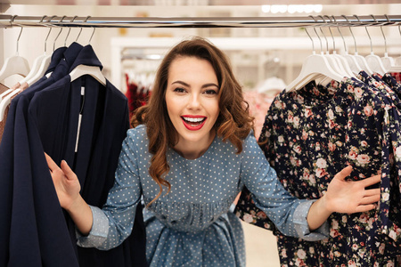 快乐的年轻女人站在衣服店图片