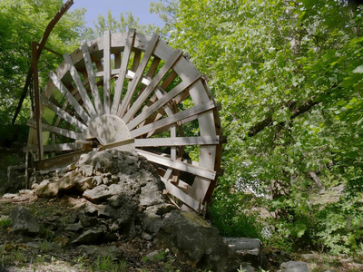 农村一条河上的旧水车照片