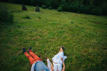情侣手牵手在绿色的草地上