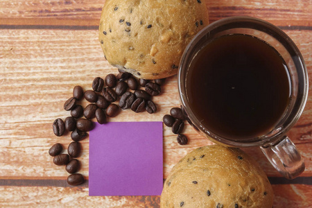 早上早餐概念与咖啡，面包，它注意到关于木制背景的帖子