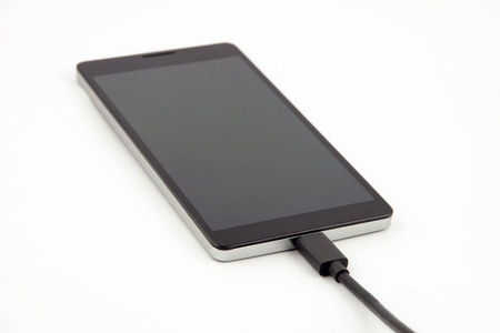 一部手机智能手机附加黑色充电电缆在白色背景上的特写视图
