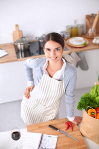 制作健康食品站在厨房里微笑的女人