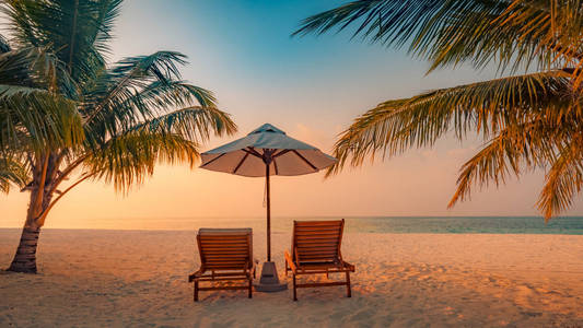 浪漫的海滩场景。沙滩椅和棕榈树。忧郁的蓝色天空和蓝色泻湖。豪华旅游夏季假日背景概念