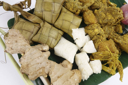 马来西亚菜巴东 Ayam 或干咖喱鸡和 Ketupat 鼻翼 汤圆 在木制的背景