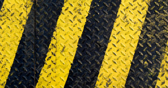 黑色和黄色标线涂料上防滑金属背景