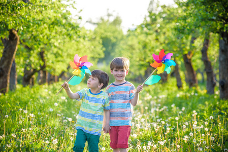 两个快乐的孩子们在花园里玩风车