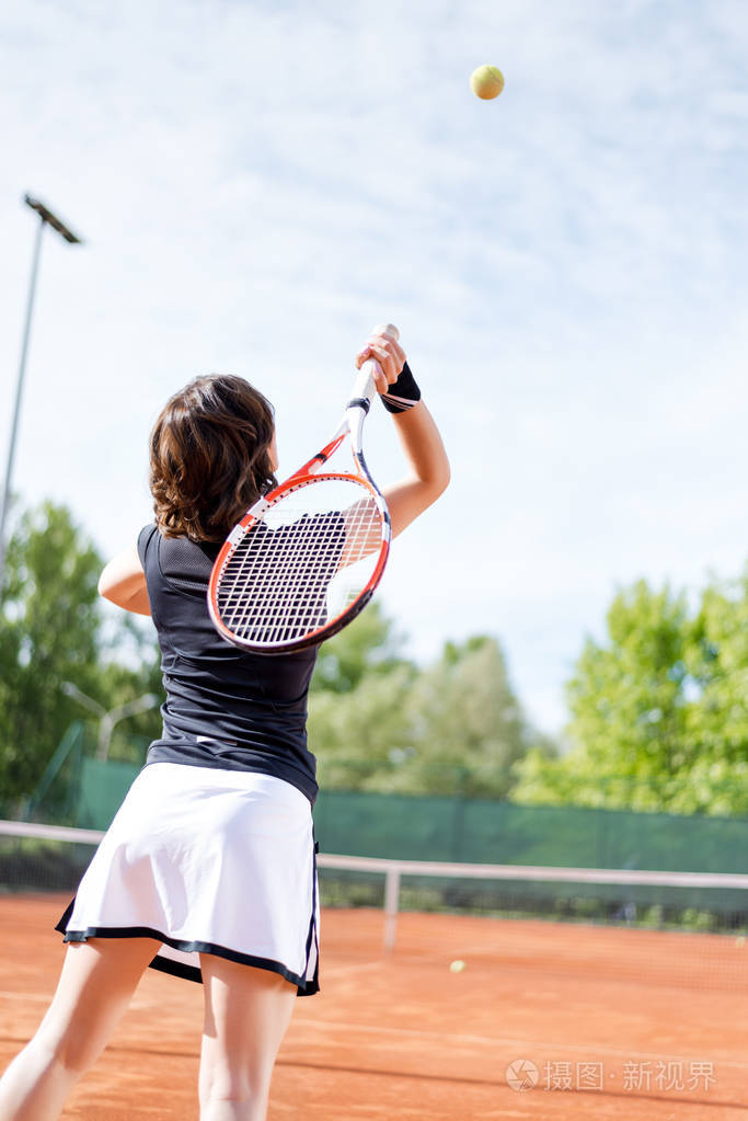 在开放的网球场上年轻漂亮的女孩