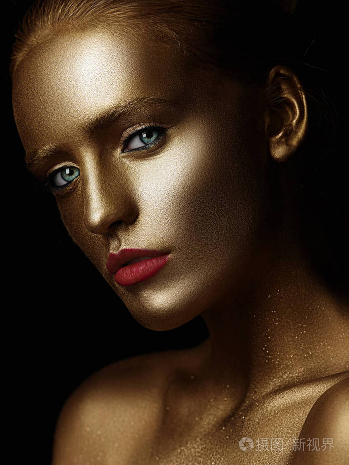 脸被彩色金漆.金黄闪耀的肌肤.工作室黑色背景