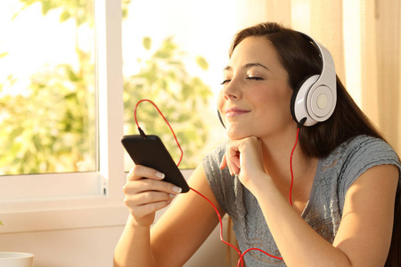轻松的女人用耳机听音乐
