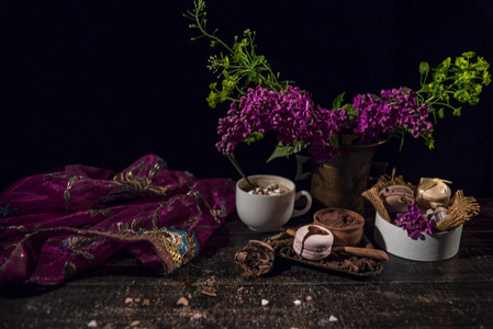 与咖啡和饼干铜编织花瓶里的木桌上的东方样式老的流动紫色透明围巾
