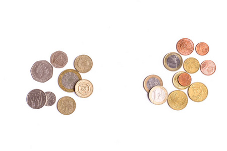 英国英镑硬币和白色背景上的欧元硬币