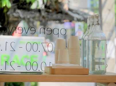 咖啡店玻璃窗旁的纸杯和水