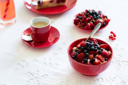 健康的早餐 奶酪和酸奶 草莓 覆盆子和蓝莓 咖啡 樱桃芝士蛋糕和新鲜成熟的浆果板