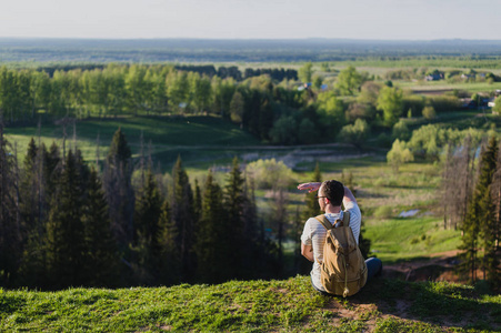 山顶背影年轻男子与背包站在边缘,美丽的峡谷旅游和凯旋举起手.