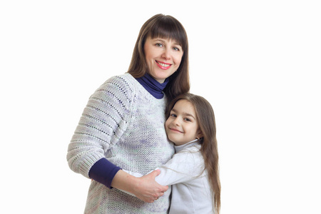 肖像的可爱的妈妈和女儿站在工作室里，抱着一个白色的背景上孤立