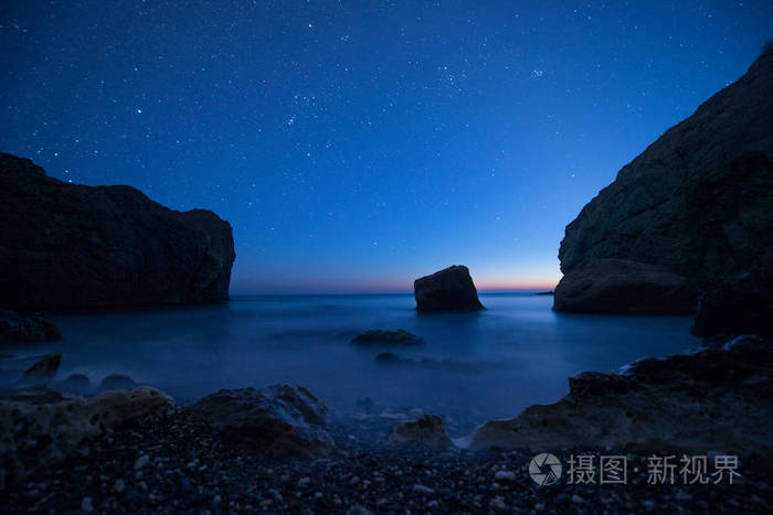 风景名胜岩石海边日落的星空下