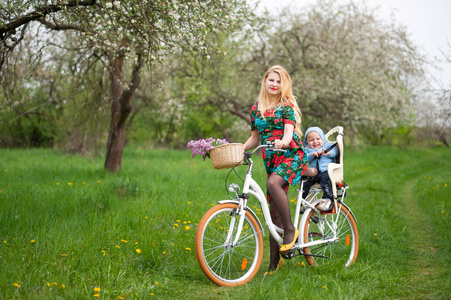婴儿的自行车椅子金发女性骑城市自行车