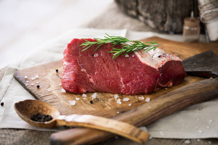 生牛肉整块洒上盐和胡椒和迷迭香树叶