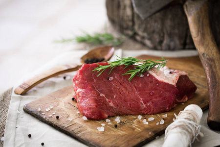 生牛肉整块洒上盐和胡椒和迷迭香树叶