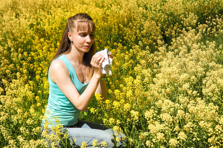 春天的花 花粉 豚草的过敏反应。季节性过敏。女人在背景春天公园吹她的鼻子