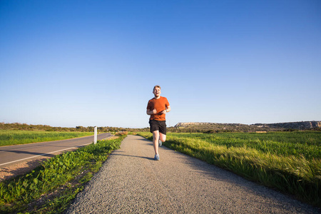 男性健身跑步运动员在冲刺 (sprint) 在极快的速度,在美丽的风景照片