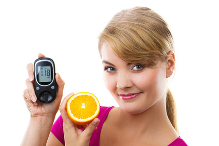 幸福的女人抱着血糖仪和橙色，测量和检查血糖水平的概念