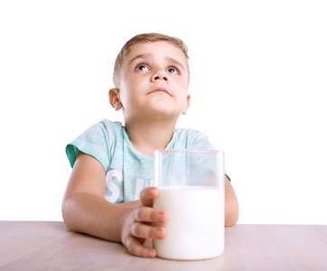 梦幻和可爱的男婴，都用透明的玻璃全有机牛奶在手，孤立的白色背景上的蓝色 t 恤