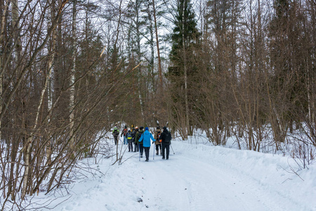 在冰雪覆盖的森林旅游的游客一小群