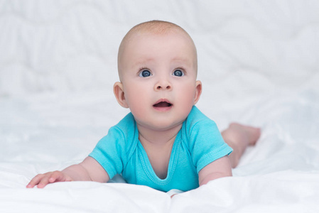 可爱的宝宝女孩或男孩与蓝色的大眼睛，印件蓝色的衬衫