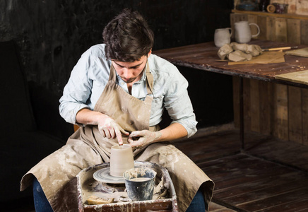 陶器 车间 陶瓷艺术概念年轻男性大师作品用手和波特轮，布鲁内特的男性手指造型一些新的水罐，从原料粘土与水，特写