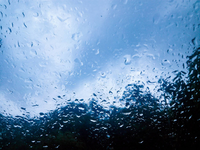玻璃上的雨和蓝色多云图片