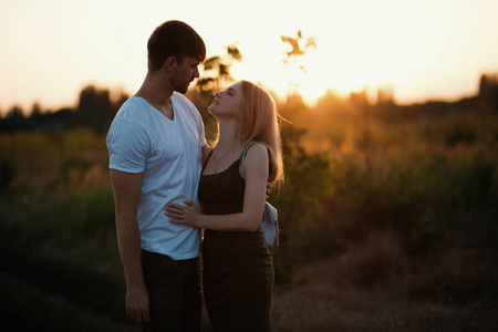 日落的浪漫情侣.在日出或日落时相爱的两人.男人和女人对场照片