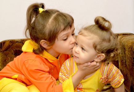 这个女孩亲吻小妹妹.肖像照片