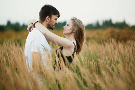 在日出或日落时相爱的两人.男人和女人对场照片