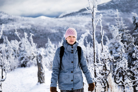 女人在冬季徒步在山高