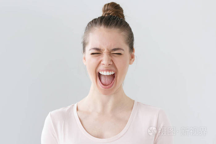 户内写真年轻美丽的女人大声尖叫情感表达在脸上闭着
