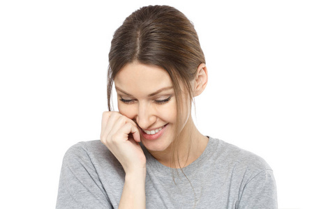 欧洲女人微笑腼腆的年轻欧洲女人穿着灰色顶部绑的头发与松散俯视和